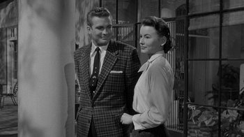 Movie still from “Queen Bee” (1955), directed by Ranald MacDougall – A man and a woman standing next to each other; Medium shot, Over the shoulder angle