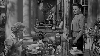 Movie still from “Queen Bee” (1955), directed by Ranald MacDougall – A black - and - white photo of people sitting at a table; Medium shot, High angle