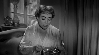 Movie still from “Queen Bee” (1955), directed by Ranald MacDougall – An older woman is holding a tea pot; Close Up shot, High angle