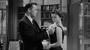 Movie still from “Queen Bee” (1955), directed by Ranald MacDougall – A man and a woman in a library; Medium shot, Low angle
