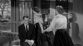 Movie still from “Queen Bee” (1955), directed by Ranald MacDougall – A man and a woman holding a little girl in front of another man; Medium shot, Over the shoulder angle