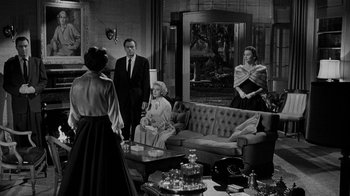 Movie still from “Queen Bee” (1955), directed by Ranald MacDougall – A black and white photo of people in a living room; Wide shot, Over the shoulder angle
