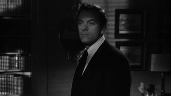 Movie still from “Queen Bee” (1955), directed by Ranald MacDougall – Black and white photograph of a man wearing a suit and tie; Close Up shot, Low angle
