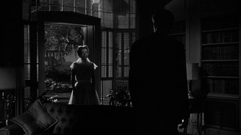 Movie still from “Queen Bee” (1955), directed by Ranald MacDougall – A man and a woman looking at each other in front of a mirror; Medium shot, Low angle