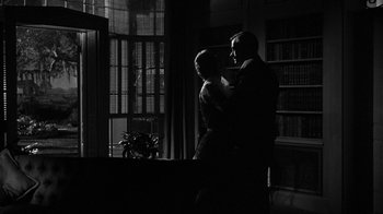 Movie still from “Queen Bee” (1955), directed by Ranald MacDougall – A man and a woman standing next to each other in a room; Medium shot, Low angle