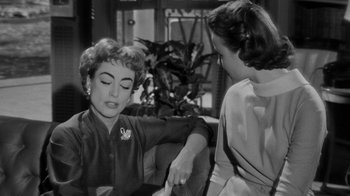 Movie still from “Queen Bee” (1955), directed by Ranald MacDougall – Two women sitting on a couch talking to each other; Medium shot, Over the shoulder angle