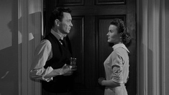 Movie still from “Queen Bee” (1955), directed by Ranald MacDougall – A man and a woman standing next to each other; Medium shot, Over the shoulder angle