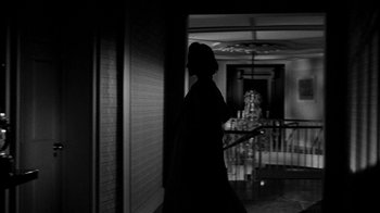 Movie still from “Queen Bee” (1955), directed by Ranald MacDougall – A woman walking down the hall way of a house; Wide shot, Low angle