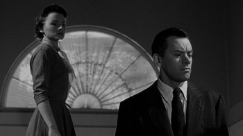 Movie still from “Queen Bee” (1955), directed by Ranald MacDougall – A black and white photo of a man and a woman; Medium shot, Low angle