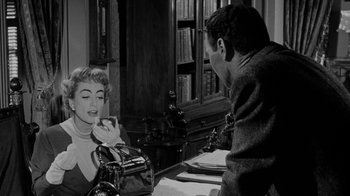 Movie still from “Queen Bee” (1955), directed by Ranald MacDougall – A man and a woman sitting at a table; Medium shot, Over the shoulder angle