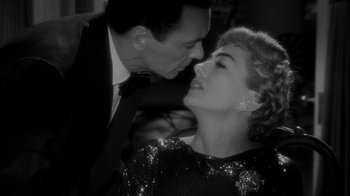Movie still from “Queen Bee” (1955), directed by Ranald MacDougall – A man and a woman kissing in a black and white photo; Close Up shot, High angle