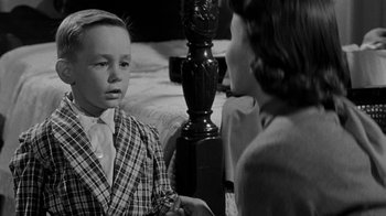 Movie still from “Queen Bee” (1955), directed by Ranald MacDougall – A boy and a woman talking to each other in a room; Close Up shot, Over the shoulder angle