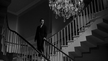 Movie still from “Queen Bee” (1955), directed by Ranald MacDougall – A man in a suit walking down a staircase; Wide shot, Low angle