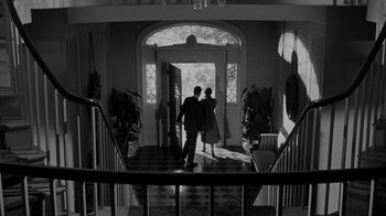 Movie still from “Queen Bee” (1955), directed by Ranald MacDougall – A man and a woman walking down the hall way of a house; Wide shot, Low angle