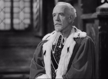 Movie still from “Queen Christina” (1933), directed by Rouben Mamoulian – An older man wearing a robe and a crown; Medium shot, Low angle