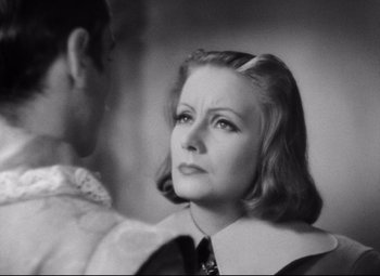 Movie still from “Queen Christina” (1933), directed by Rouben Mamoulian – An old photo of a woman looking at a man; Close Up shot, Over the shoulder angle