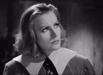 Movie still from “Queen Christina” (1933), directed by Rouben Mamoulian – A black - and - white photo of a woman in a tie; Close Up shot, Over the shoulder angle