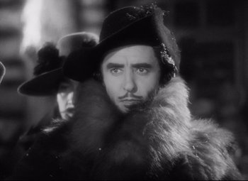 Movie still from “Queen Christina” (1933), directed by Rouben Mamoulian – A black and white photo of a man in a fur coat and a hat; Close Up shot, Low angle