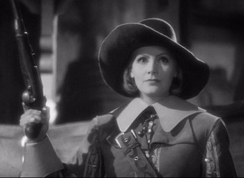 Movie still from “Queen Christina” (1933), directed by Rouben Mamoulian – A black and white photo of a woman holding a camera; Medium shot, Low angle