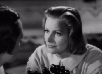 Movie still from “Queen Christina” (1933), directed by Rouben Mamoulian – An old black and white photo of a woman holding cherries; Close Up shot, Over the shoulder angle