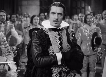 Movie still from “Queen Christina” (1933), directed by Rouben Mamoulian – A black and white photo of a man in a renaissance costume; Medium shot, Over the shoulder angle