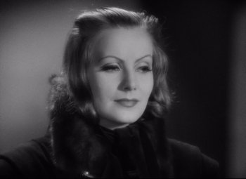 Movie still from “Queen Christina” (1933), directed by Rouben Mamoulian – An old photo of an older woman in a black coat; Close Up shot, High angle