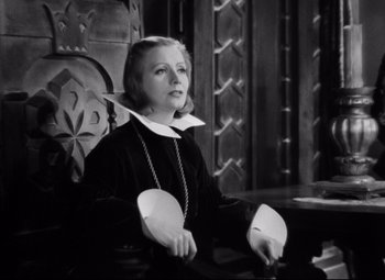 Movie still from “Queen Christina” (1933), directed by Rouben Mamoulian – An old photo of a woman sitting in a chair; Medium shot, High angle