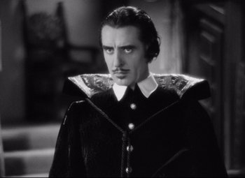 Movie still from “Queen Christina” (1933), directed by Rouben Mamoulian – A black and white photo of a man with a mustache; Medium shot, Low angle