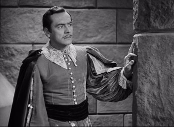 Movie still from “Queen Christina” (1933), directed by Rouben Mamoulian – A black and white photo of a man dressed in renaissance clothing; Medium shot, High angle