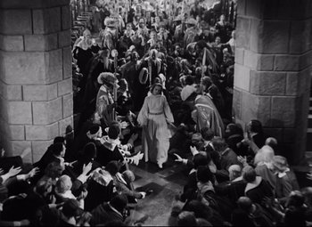 Movie still from “Queen Christina” (1933), directed by Rouben Mamoulian – An old photo of a crowd of people gathered around a woman; Extreme Wide shot, High angle