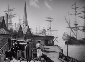 Movie still from “Queen Christina” (1933), directed by Rouben Mamoulian – A black and white photo of people standing on a pier; Extreme Wide shot, High angle