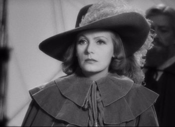 Movie still from “Queen Christina” (1933), directed by Rouben Mamoulian – A black and white photo of a woman wearing a hat; Close Up shot, Over the shoulder angle