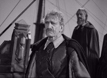 Movie still from “Queen Christina” (1933), directed by Rouben Mamoulian – A black and white photo of a man with a beard; Medium shot, Over the shoulder angle