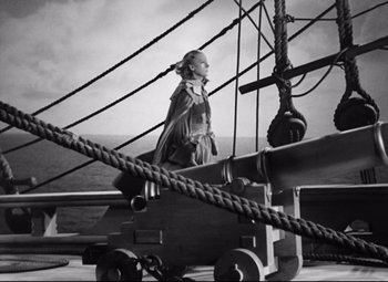 Movie still from “Queen Christina” (1933), directed by Rouben Mamoulian – A woman standing next to a cannon on top of a boat; Wide shot, High angle
