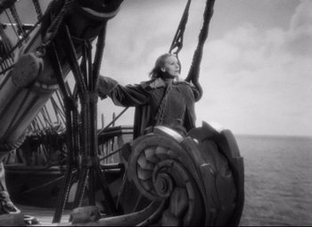 Movie still from “Queen Christina” (1933), directed by Rouben Mamoulian – A woman standing on a boat in the water; Wide shot, Low angle
