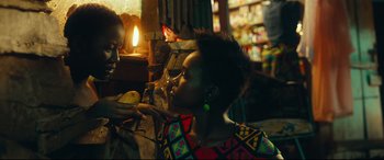 Movie still from “Queen of Katwe” (2016), directed by Mira Nair – A woman is cutting a banana with a knife in her hand; Close Up shot, Over the shoulder angle