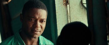 Movie still from “Queen of Katwe” (2016), directed by Mira Nair – A person wearing a green shirt; Close Up shot, Over the shoulder angle