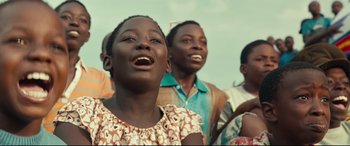Movie still from “Queen of Katwe” (2016), directed by Mira Nair – A group of people standing next to each other on a field; Close Up shot, Low angle