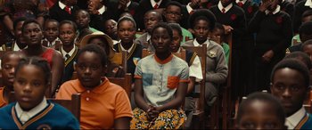 Movie still from “Queen of Katwe” (2016), directed by Mira Nair – A group of young people sitting in rows of chairs; Medium shot, High angle