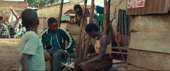 Movie still from “Queen of Katwe” (2016), directed by Mira Nair – A couple of people that are playing a game of chess; Medium shot, Over the shoulder angle