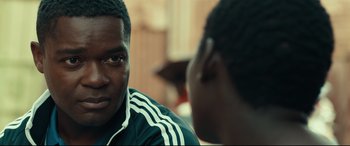 Movie still from “Queen of Katwe” (2016), directed by Mira Nair – Two young men sitting in front of each other talking; Close Up shot, Over the shoulder angle
