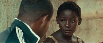 Movie still from “Queen of Katwe” (2016), directed by Mira Nair – A young man and a young woman looking at one another; Close Up shot, Over the shoulder angle