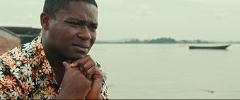 Movie still from “Queen of Katwe” (2016), directed by Mira Nair – A person holding his hand to his face; Close Up shot, High angle