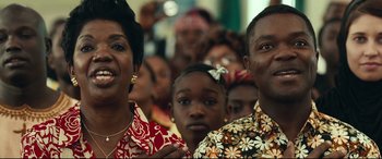 Movie still from “Queen of Katwe” (2016), directed by Mira Nair – A group of people standing in front of each other; Close Up shot, Low angle