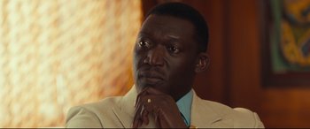 Movie still from “Queen of Katwe” (2016), directed by Mira Nair – A person with his hand on his chin; Close Up shot, High angle