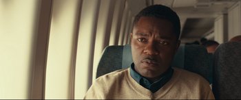 Movie still from “Queen of Katwe” (2016), directed by Mira Nair – A person sitting in a chair; Close Up shot, Over the shoulder angle