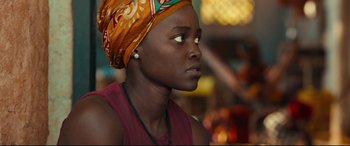 Movie still from “Queen of Katwe” (2016), directed by Mira Nair – A woman with a head scarf on looking up; Close Up shot, Over the shoulder angle