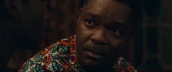 Movie still from “Queen of Katwe” (2016), directed by Mira Nair – A person wearing a colorful shirt; Close Up shot, Over the shoulder angle