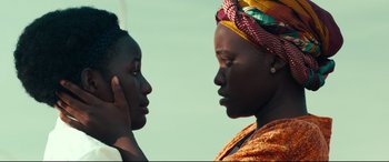 Movie still from “Queen of Katwe” (2016), directed by Mira Nair – Two women are facing each other and one of them has her hand to her ear; Close Up shot, Over the shoulder angle