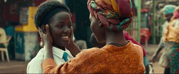 Movie still from “Queen of Katwe” (2016), directed by Mira Nair – Two women are talking to each other outside; Close Up shot, Over the shoulder angle